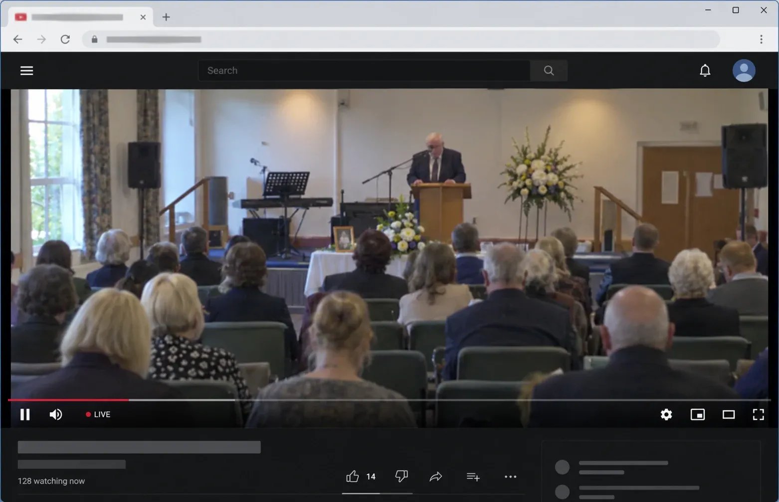 Memorial livestream with a speaker at a lectern, the audience and live video-player controls